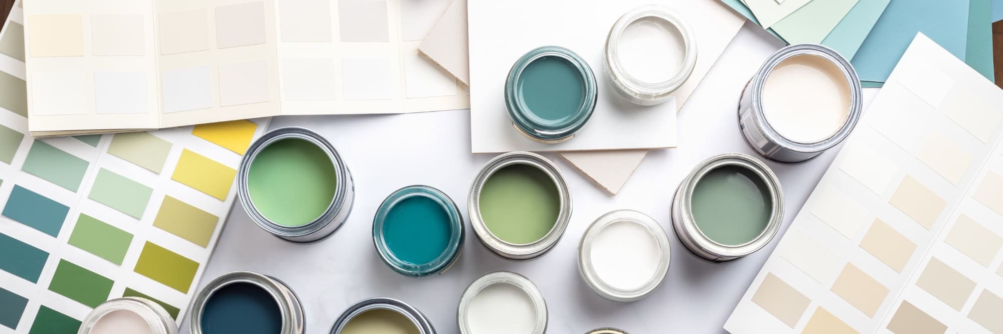 Open paint cans with green, teal, and neutral color swatches