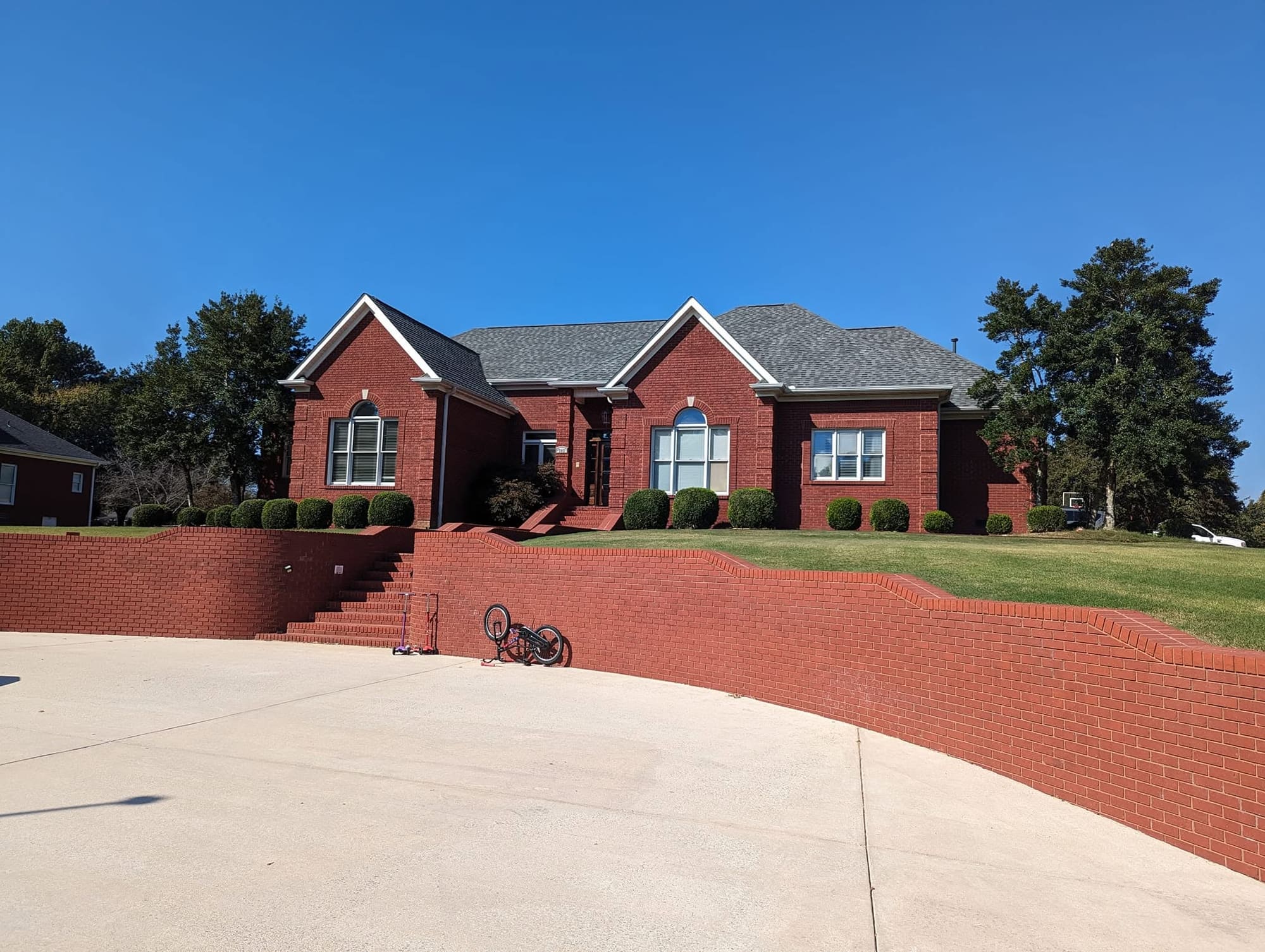 Before: red brick home exterior and retaining wall